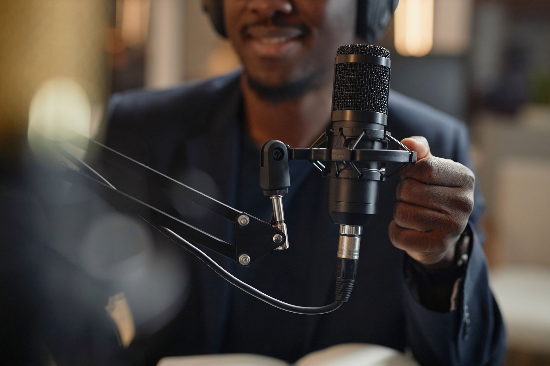 Man Adjusting Studio Microphone during Podcast